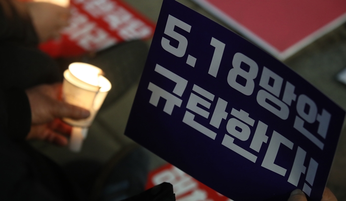 서울 영등포구 자유한국당사 앞에서 한국진보연대가 주최한 '5·18 망언 비호하는 자유한국당 해체 촛불문화제'에서 한 시민이 촛불과 '5.18 망언 규탄한다'는 문구가 적힌 피켓을 들고 있다. / 뉴시스
