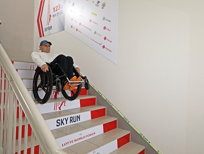롯데월드타워에서 ‘휠체어 계단 내려가기’ 기네스 기록에 도전 중인 하키도쿠 선수가 한 계단 한 계단 조심스럽게 내려가고 있다. / 롯데물산