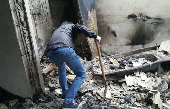 강원산불로 폐허가 된 집에서 한 주민이 잔해를 살펴보고 있다. /뉴시스