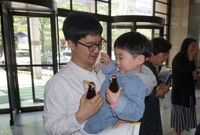 8일 오전 서울 영등포구 한세실업 본사에서 열린 한세예스24어린이집 행사에서 한세실업 이만재 과장이 자녀를 안고 웃고 있다. / 한세예스24홀딩스