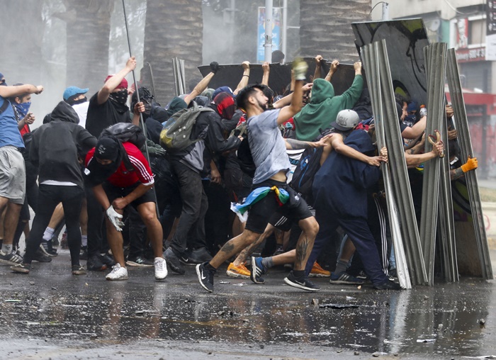 칠레 반정부 시위대가 경찰의 물대포를 막고 있다. /AP-뉴시스