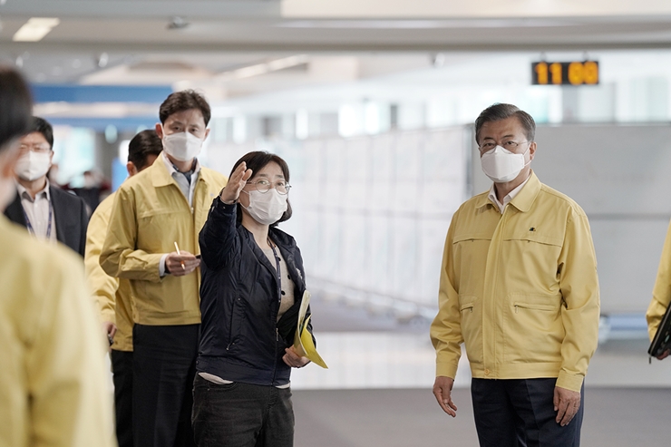 문재인 대통령이 지난 7일 인천공항 검역현장을 방문해 안내를 받고 있다. /청와대