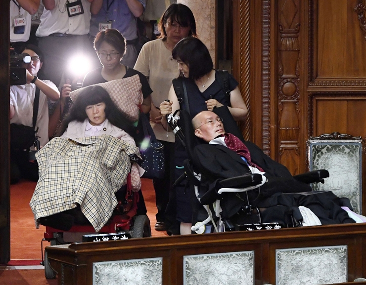 일본 도쿄에서 지난해 8월 뇌성마비 중증장애인인 기무라 에이코 의원(가운데)과 루게릭병 환자인 후나고 야스히코 의원(오른쪽) 이 임시국회 첫날 등원하고 있다. 두 사람은 지난해 7월 21일 치러졌던 참의원 선거에서 신생 정당인 '레이와신센구미'(れいわ新選組) 비례대표 자격으로 출마해 당선됐다. 일본에서 중증 장애인이 국회의원에 당선된 것은 이들이 처음이다. /AP-뉴시스