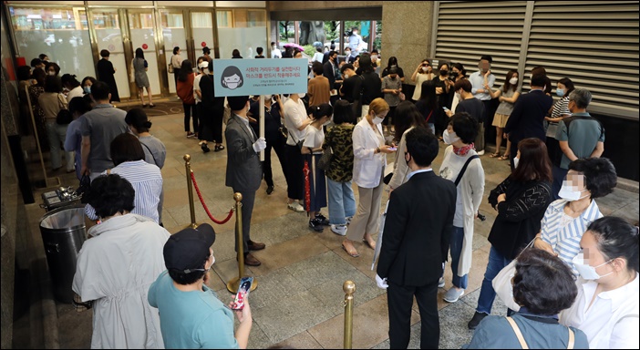 지난 6월 면세명품대전 행사가 열린 서울의 한 백화점 앞에 대기자들이 줄을 서고 있다. / 뉴시스