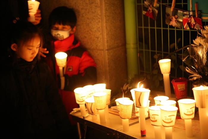 충격적인 아동학대 사망사건이 발생했던 2013년, 추모식에 참석한 아이들이 촛불을 밝히고 있다. /뉴시스