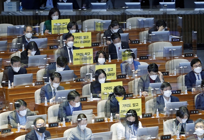 정의당 의원들이 지난 2월 26일 서울 여의도 국회 본회의에서 가덕도 관련 법안을 비판하는 피켓을 의석에 붙여 놓고 있다. / 뉴시스