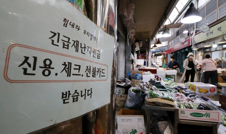 코로나 상생 국민지원금 신청이 시작된 지난 6일 오전 서울 중로구 통인시장에는 '긴급재난지원금 받습니다'라고 적힌 안내문이 게시돼 있다. /뉴시스