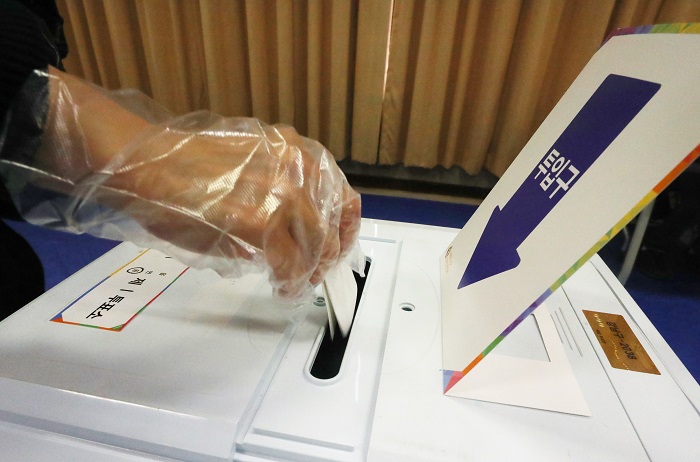 2021 재·보궐선거 투표일인 7일 오전 서울 강남구 단국대학교 사범대학 부속중학교 체육관에 마련된 대치1동 제1투표소에서 한 시민이 투표함에 투표용지를 넣고 있다./뉴시스