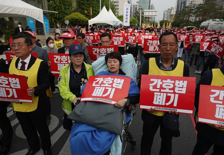 5월 3일 여의도 국회 앞에서 곽지연 대한간호조무사협회장이 '간호법 폐기' 푯말을 들고 휠체어에 앉아 참석하고 있다. / 뉴시스