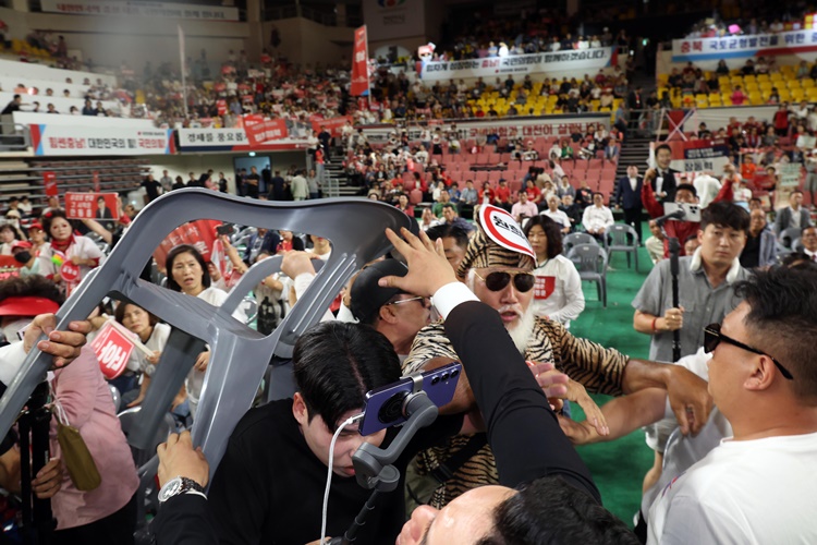 전날(15일) 오후 충남 천안시 유관순체육관에서 열린 국민의힘 제4차 전당대회 대전·세종·충북·충남 합동연설회에서 참석자들 일부가 연설중인 한동훈 후보에게 '배신자'라고 외치며 의자를 집어 던지려고 하자 경호원과 당직자들이 제지하고 있다.  /뉴시스