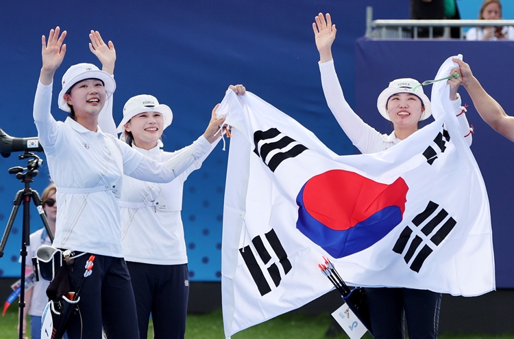 임시현, 전훈영, 남수현이 28일(현지시간) 프랑스 파리 레쟁발리드에서 열린 파리 올림픽 양궁 여자 단체전 결승 중국과의 경기에서 슛오프 끝에 승리하며 금메달을 확정 지은 뒤 태극기를 들고 기뻐하고 있다. / 뉴시스