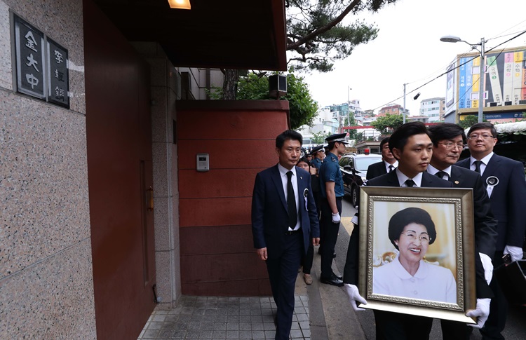 더불어민주당을 비롯한 야권이 고(故) 김대중 전 대통령(DJ) 동교동 사저 매각 논란과 관련해 대책을 마련하겠다고 했다. 사진은 고 이희호 김대중평화센터 이사장의 영정이 지난 2019년 6월 14일 오전 서울 동교동 사저와 김대중도서관을 들른 뒤 사저 대문 옆에 나란히 걸린 '김대중·이희호' 문패 앞에 잠시 멈춰서 있는 모습. / 뉴시스