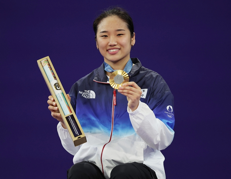 안세영이 5일(현지시각) 프랑스 파리 아레나 포르트 드 라샤펠에서 열린 2024 파리 올림픽 배드민턴 단식 시상식에서 밝은 표정으로 금메달을 들어보이고 있다. / 뉴시스