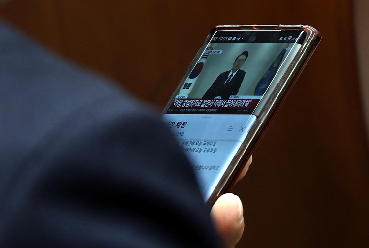 12일 오전 서울 여의도 국회에서 열린 국민의힘 원내대표 선출을 위한 의원총회에서 한 의원이 윤석열 대통령의 대국민담화 방송을 보고 있다. /뉴시스