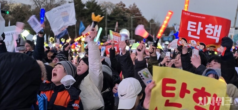 윤석열 탄핵안 가결 소식에 시민들이 두손을 번쩍 들고 환호하고 있다. / 시사위크 