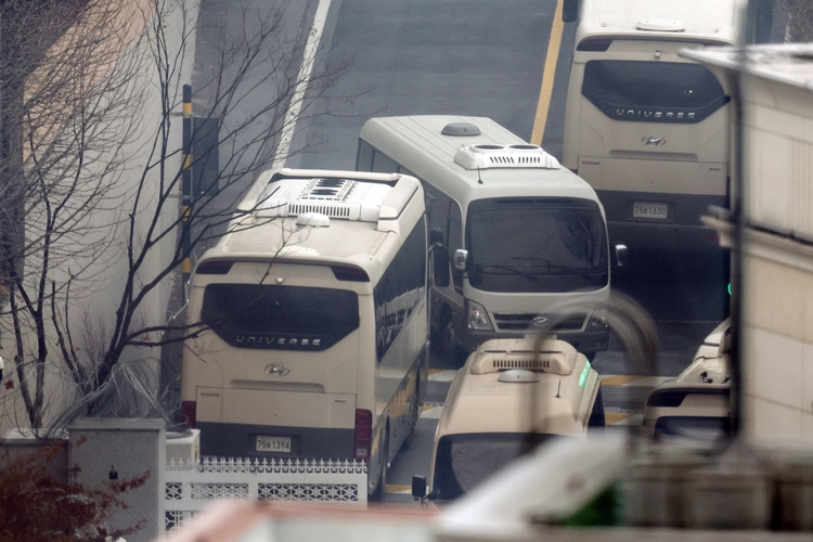 14일 서울 용산구 한남동 대통령 관저 입구에서 버스가 이동하고 있다. / 뉴시스