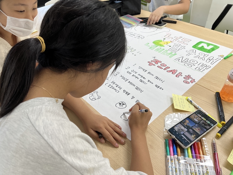 아동의 디지털 환경에 대한 위험성을 알린 바 있는 초록우산이 11일  ‘모든 아동의 안전한 디지털 세상을 위한 선언문’을 발표했다. 사진은 지난해 온라인 세이프티 차원애서 한 아동이 디지털 플랫폼 개선을 위한 플랫폼 주의사항을 작성하는 모습이다. / 초록우산