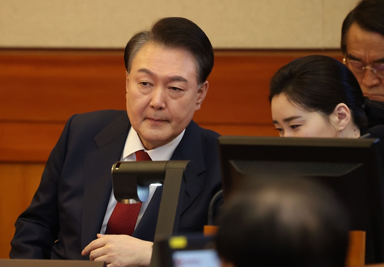윤석열 대통령이 13일 서울 종로구 헌법재판소에서 열린 탄핵심판 8차 변론에 출석해 변호인과 대화하고 있다. / 뉴시스