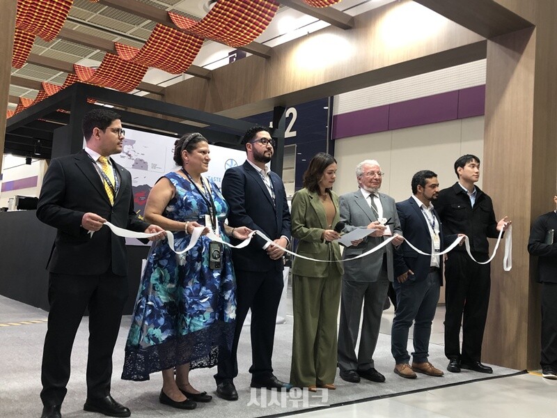 온두라스 부스 앞에서 로돌포 파스토르 파스케예 주한 온두라스 대사(오른쪽 세번째), 신디 로드리게스 온두라스 국제외교협력부 차관(오른쪽 네번째), 인플루언서 박민규 씨(오른쪽 끝) 등이 테이프 커팅식을 진행하고 있는 모습이다./ 임다영 인턴기자