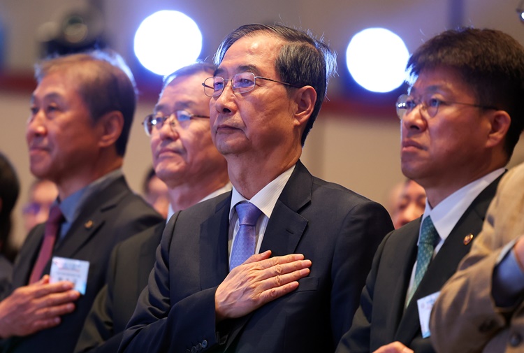 한덕수 대통령 권한대행 국무총리가 29일 서울 강남구 건설회관에서 열린 해외건설 1조달러 수주 및 60주년 기념식에서 국기에 경례하고 있다. /뉴시스