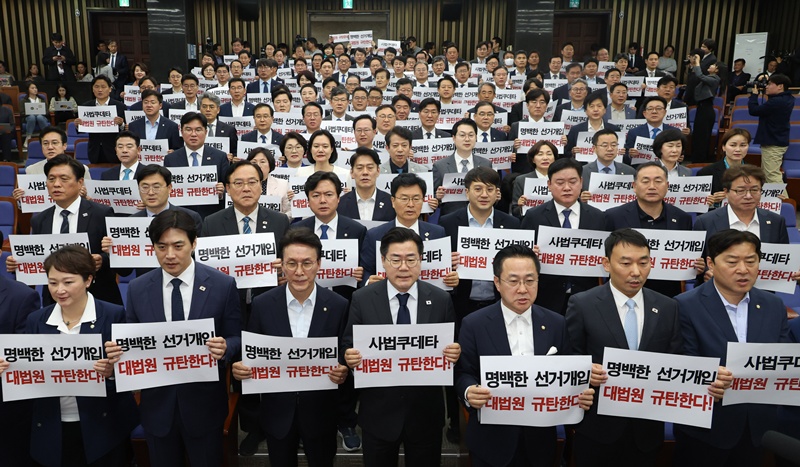  박찬대 더불어민주당 대표 직무대행 겸 원내대표와 의원들이 1일 오후 서울 여의도 국회에서 열린 긴급 의원총회에서 ‘사법쿠데타, 대법원 규탄’이라고 적힌 손팻말을 들고 구호를 외치고 있다. / 뉴시스