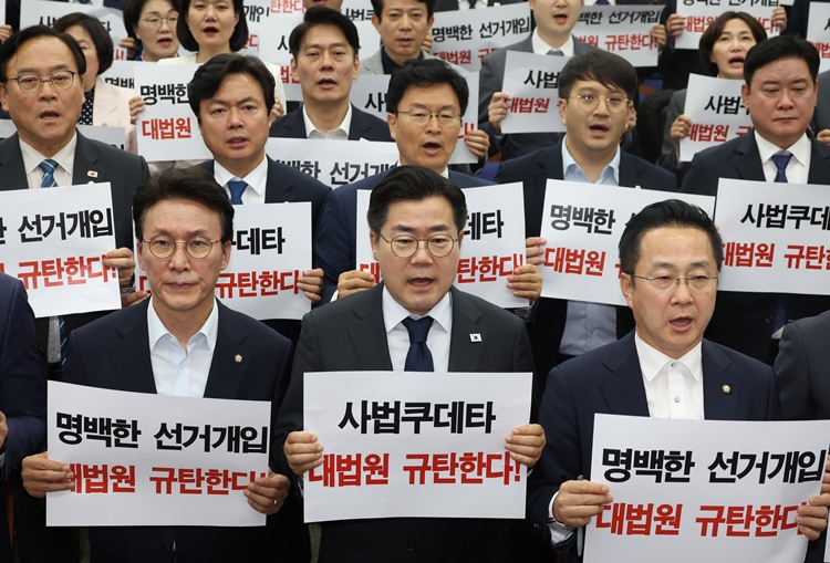 대법원이 이재명 더불어민주당 대선 후보의 공직선거법 위반 사건을 유죄 취지로 파기환송하자, 민주당은 “대법원의 부당한 대선개입”으로 규정하며 격앙된 반응을 보였다. 사진은 박찬대 대표 직무대행 겸 원내대표와 의원들이 1일 국회에서 열린 긴급 의원총회에서 손피켓을 들고 구호를 외치고 있는 모습. / 뉴시스