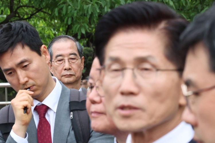 한덕수 무소속 대선 후보가 8일 서울 여의도 국회 내 카페에서 단일화 관련 회동을 마친 뒤 김문수 국민의힘 대선 후보의 브리핑을 경청하고 있다. /뉴시스