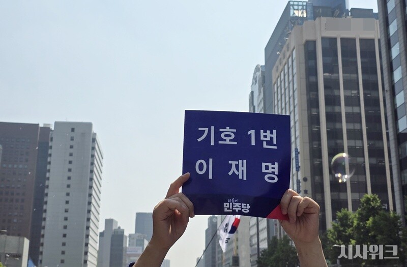 이재명 후보 출정식에 참가한 지지자가 '기호 1번 이재명'이란 글귀가 쓰여진 팻말을 하늘 높이 들고 있는 모습. / 사진=김두완 기자