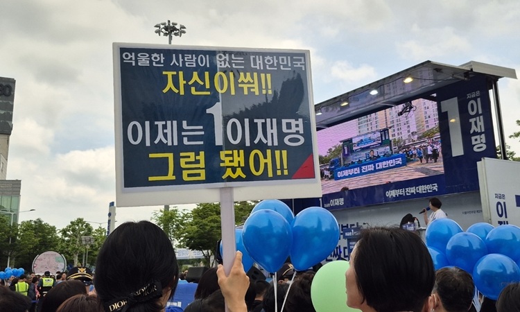 17일 광주 광주 서구 김대중컨벤션센터 광장에서 진행된 이재명 더불어민주당 대선 후보의 집중유세 현장에서 한 지지자가 이 후보를 응원하는 피켓을 들고 고 있다. / 권신구 기자