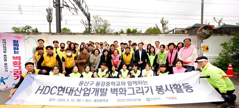 HDC현대산업개발은 15일 도시정비부문 임직원과 용산구 주민, 용강중학교 학생 등 40여 명과 함께 서울시 용산구 용강중학교 일대 담장 벽화그리기 봉사활동을 진행했다. (사진 앞에서 두 번째 줄 오른쪽 다섯 번째부터 권충환 용강중학교장, 강경민 HDC현대산업개발 도시정비부문장, 박희영 용산구청장) / HDC현대산업개발