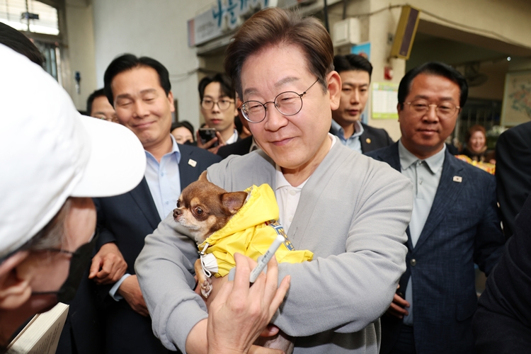이재명 더불어민주당 대선 후보가 21일 반려인 표심잡기에 나섰다. 사진은 이 후보가 지난 11일 전남 강진군 강진오감통시장에서 한 주민의 강아지를 안아보고 있는 모습. / 뉴시스