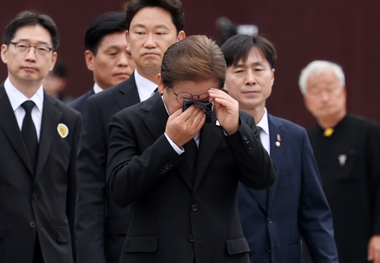 이재명 더불어민주당 대선후보가 고 노무현 전 대통령 16주기인 23일 경남 김해시 진영읍 봉하마을을 찾아 노 전 대통령의 묘역을 참배한 이동하며 눈물을 훔치고 있다. / 뉴시스