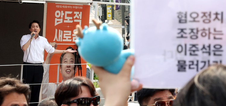 30일 오후 서울 동작구 중앙대학교 후문에서 대학생들이 유세를 펼치는 이준석 개혁신당 대선후보를 향해 혐오 발언 규탄 피켓을 들어 보이고 있다. /뉴시스