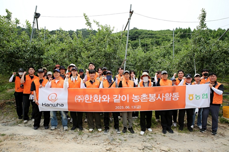 ㈜한화 임직원들이 경기도 연천군 군남면 임진농협 관내 사과농가에서 농촌 일손돕기 봉사활동을 진행한 뒤 기념사진을 촬영하고 있다. / ㈜한화