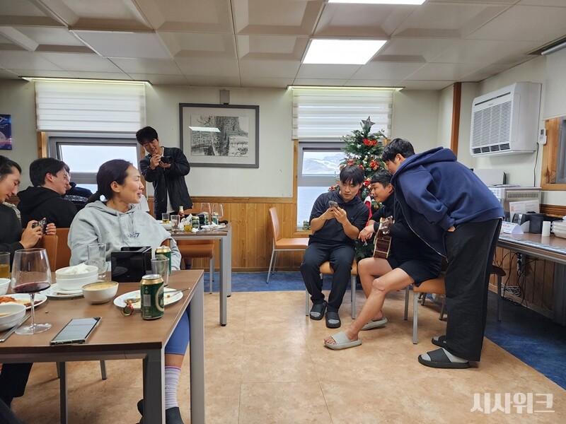 민진홍 대원의 기타공연을 지켜보는 하계대 및 월동대원들의 모습./ 사진=남극특별취재팀