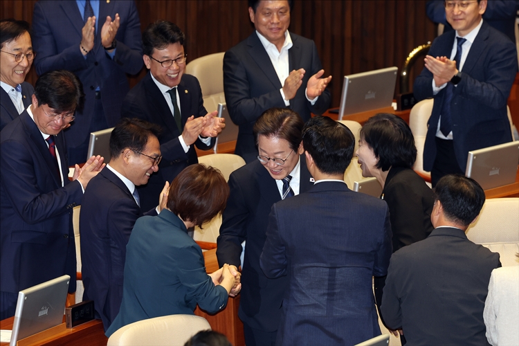이재명 대통령은 최근 야당과의 ‘협치’를 강조하는 모습을 보이고 있는 반면 더불어민주당은 야당을 향한 ‘강공 모드’에 돌입한 모습이다. 사진은 이 대통령이 지난달 26일 국회에서 열린 제426회국회(임시회) 제2차 본회의에서 2025년도 제2회 추가경정예산안에 대한 정부의 시정연설을 하기위해 본회의장에 입장하며 민주당 의원들과 인사하고 있는 모습. / 뉴시스