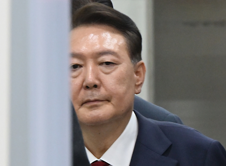 윤석열 전 대통령이 지난 9일 서울 서초구 서울중앙지법에서 열린 직권남용 등 혐의 영장실질심사(구속 전 피의자 심문)를 마친 뒤 대기 장소인 서울구치소로 이동하기 위해 법원을 나서고 있는 모습. 윤 전 대통령은 10일 구속영장 발부로 재구속됐다.