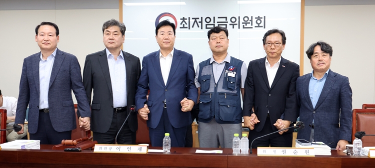 최저임금위원회 이인재 위원장과 권순원 공익위원, 류기정 사용자 위원, 류기섭 근로자 위원 등이 지난 10일 밤 세종시 정부세종청사에서 2026년도 적용 최저임금안을 합의로 결정한 뒤 손을 맞잡고 있다. 내년도 최저임금은 1만 320원으로 결정됐다. / 뉴시스