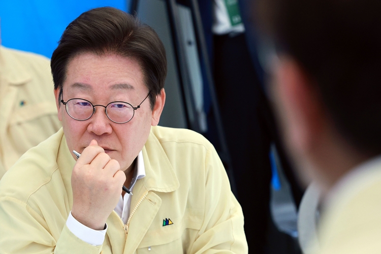 이재명 대통령이 21일 기록적인 폭우가 쏟아진 경남 산청군 산청읍 행정복지센터 앞에 마련된 호우 피해 통합지원본부에서 관계자들로부터 피해 상황 설명을 듣고 있다. / 뉴시스