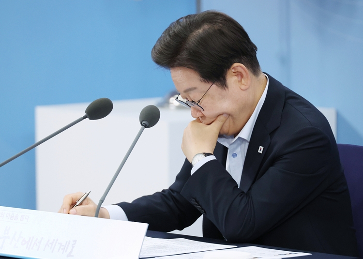 이재명 대통령이 지난 25일 부산 부경대에서 열린 타운홀미팅 '부산의 마음을 듣다' 지역 주민 간담회에서 자료를 살펴보고 있다. (대통령실통신사진기자단) / 뉴시스