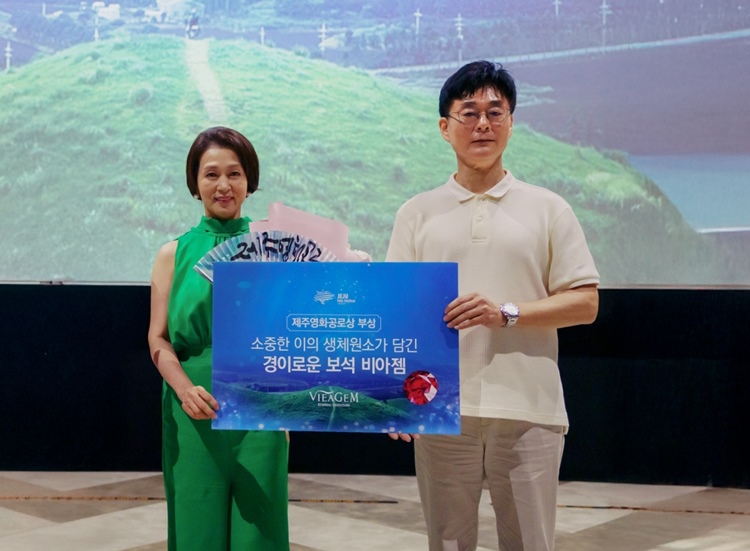 최필재(사진 우측) 비아생명공학 대표이사가 배우 문희경에게 제주영화제 공로상을 시상하고 생체보석 ‘비아젬’ 부상과 함께 기념사진을 촬영하고 있다. / 보람그룹 