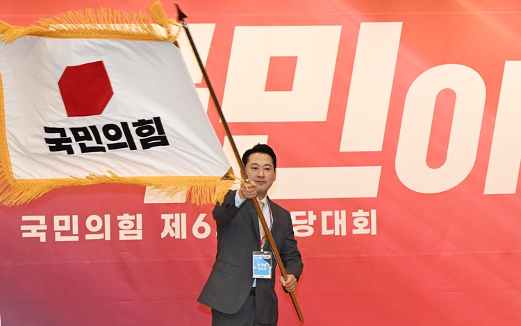 장동혁 신임 국민의힘 대표가 26일 국회도서관에서 열린 국민의힘 제6차 전당대회 결선에서 선출된 뒤 당기를 흔들고 있다. / 뉴시스