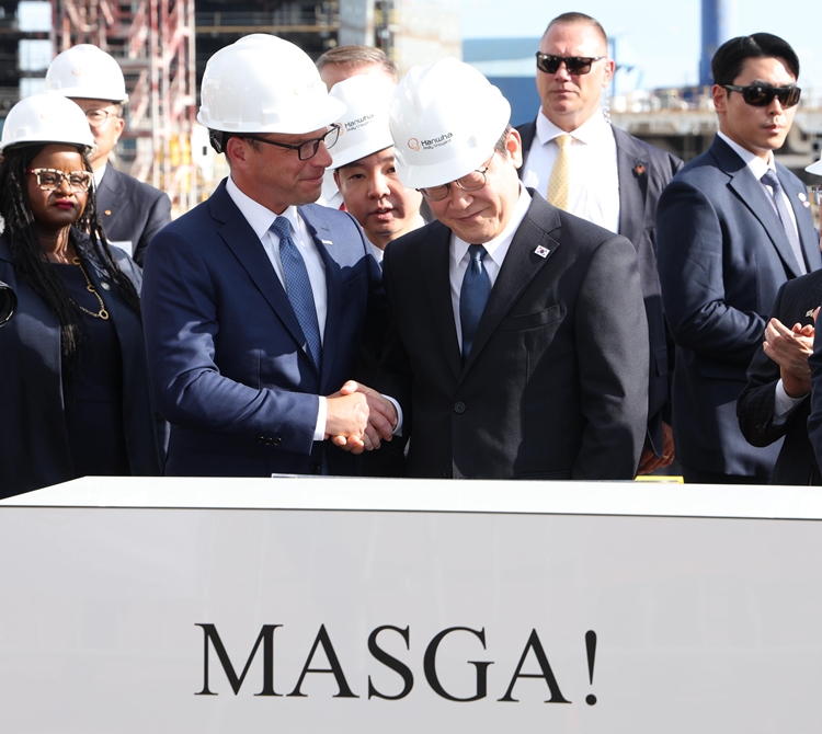 이재명 대통령이 26일(현지 시간) 필라델피아 한화 필리조선소를 방문해 방명록에 서명한 뒤 조시 샤피로 펜실베니아 주지사와 악수하고 있다. / 뉴시스