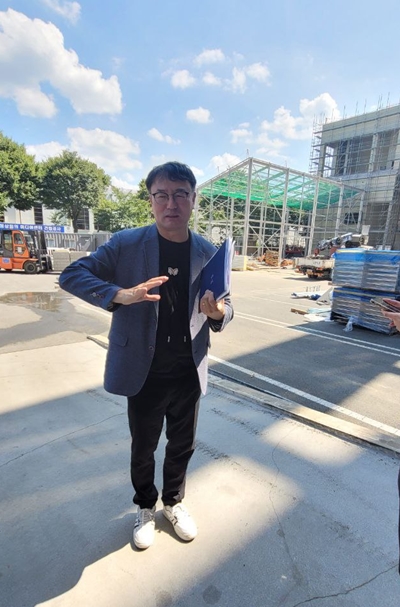 박장호 APEC준비지원단 의전홍보과 과장이 국제미디어센터 신축 공사 현장 앞에서 공정 상황을 설명하고 있다. / 이미정 기자