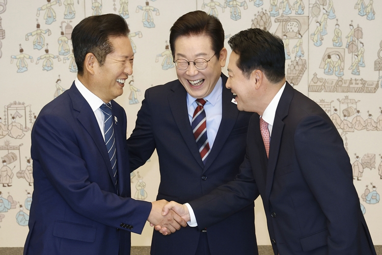 이재명 대통령이 8일 서울 용산 대통령실 청사에서 열린 여야 지도부 오찬 회동에 앞서 정청래 더불어민주당 대표와 장동혁 국민의힘 대표의 악수 모습을 보며 밝게 웃고 있다. / 뉴시스