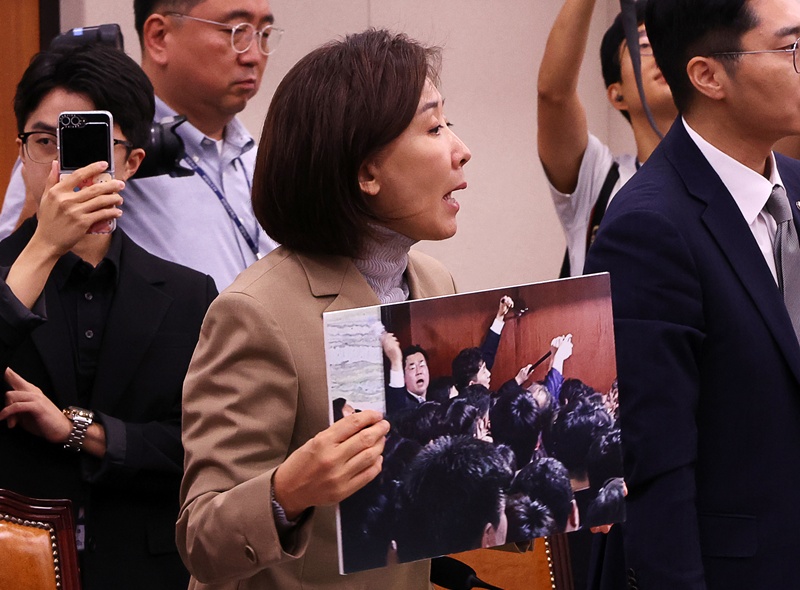 나경원 국민의힘 의원이 16일 오전 서울 여의도 국회에서 열린 법제사법위원회 전체회의에서 패스트트랙 사건 당시 사진을 들어보이고 있다. / 뉴시스
