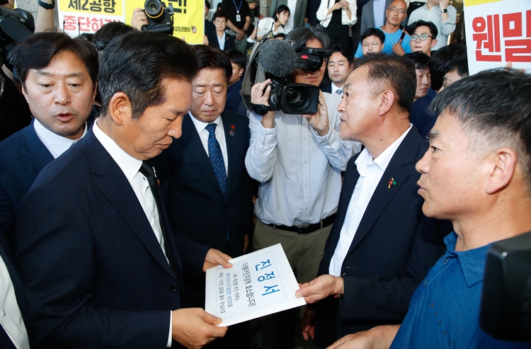 정청래 더불어민주당 대표가 17일 오전 제주도청 본관 앞에서 제주제2공항강행저지비상도민회의 관계자로부터 진정서를 받고 있다. / 뉴시스