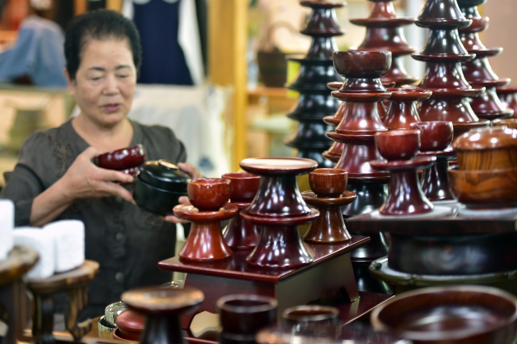 국세청에 따르면 2023년 기준 지역 특산주를 생산하는 사업체 수는 1,766개로, 이 전통주들은 온라인으로도 구입이 가능하다. 사진은 명절 차례를 위한 제기 그릇 세트를 살펴보고 있는 모습. / 뉴시스