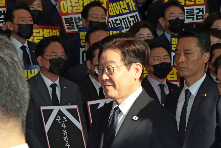 이재명 대통령이 4일 국회에서 시정연설을 위해 이동하는 가운데 국민의힘 의원들이 검은 양복과 넥타이를 매고 마스크를 착용한 채 침묵시위를 하고 있다. / 뉴시스