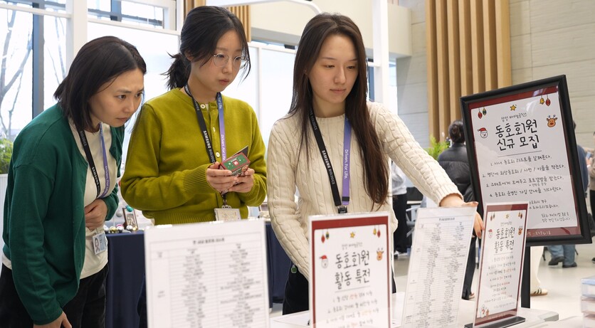 [사진자료3] 삼성바이오로직스 임직원들이 동호회 신규 회원모집 안내문을 살펴보고 있다